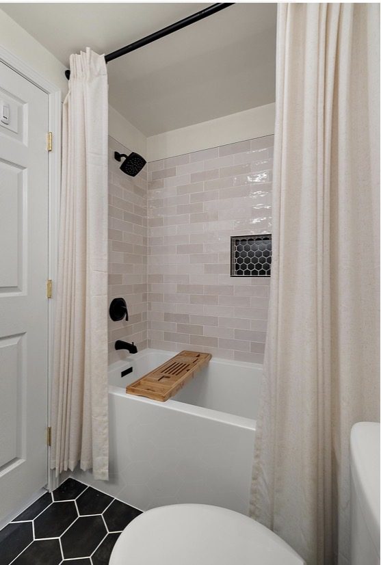 Bathroom renovation with soaking tub, subway tile, black matte hardware, and large hexagon floor tile — Downriver Michigan